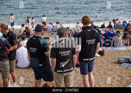 Barcelona, Spanien. Oktober 2024. Fans des Emirates-Teams aus Neuseeland folgen den Segelrennen vom Strand aus. Der zweite Tag des America's Cup Finales fand heute in Barcelona statt. Die Fans der beiden Teams Emirates und Ineos konnten das Rennen von den Stränden und Bars von Barceloneta aus verfolgen. (Foto: Paco Freire/SOPA Images/SIPA USA) Credit: SIPA USA/Alamy Live News Stockfoto