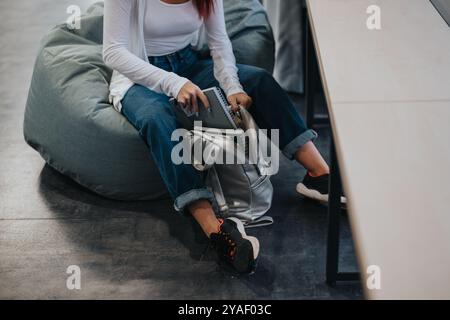 High School Schüler organisiert Rucksack in entspannter Sitzecke Stockfoto
