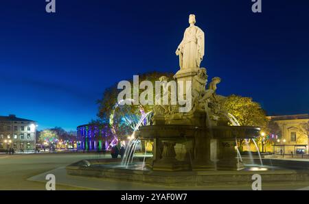 Fontaine Pradier beleuchtet bei Dämmerung in der Altstadt von Nimes Stockfoto