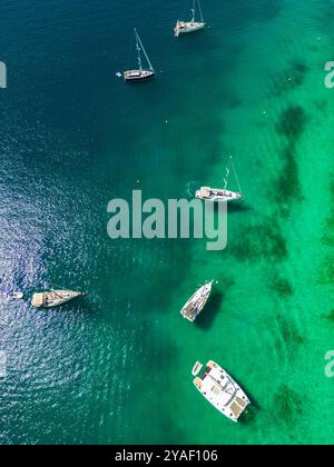 Rogoznica, Kroatien - 28. Juni 2024: Drone von oben nach unten auf Segelbooten vor Anker im wunderschönen, kristallklaren Wasser von Rogoznica, Kroatien, dem berühmten nau Stockfoto