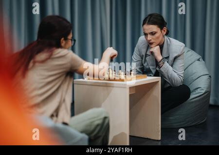 Zwei konzentrierte Frauen spielen Schach während einer intensiven Spielsession Stockfoto