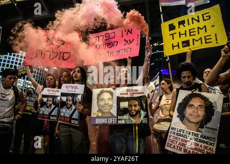 Familienmitglieder der israelischen Geiseln Matan Zangauker und Ofer Kalderon halten während der Demonstration ein Rauchfackel und Plakate mit den Fotos ihrer Angehörigen. Anhänger demonstrierten mit Familienmitgliedern der israelischen Geiseln gegen Premierminister Benjamin Netanjahu und forderten einen sofortigen Geiselvertrag und Waffenstillstand vor dem IDF-Hauptquartier. Stockfoto