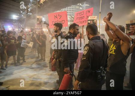 Tel Aviv, Israel. Oktober 2024. Israelische Polizeibeamte stehen im Rauch, nachdem sie während der Demonstration ein Lagerfeuer ausgelöst haben, das von Demonstranten und Familienmitgliedern der Geiseln ausgelöst wurde. Anhänger demonstrierten mit Familienmitgliedern der israelischen Geiseln gegen Premierminister Benjamin Netanjahu und forderten einen sofortigen Geiselvertrag und Waffenstillstand vor dem IDF-Hauptquartier. (Credit Image: © Matan Golan/SOPA Images via ZUMA Press Wire) NUR REDAKTIONELLE VERWENDUNG! Nicht für kommerzielle ZWECKE! Stockfoto