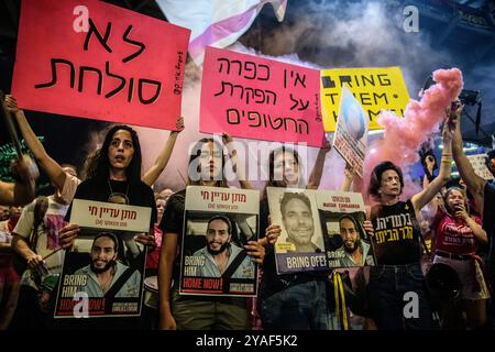 Tel Aviv, Israel. Oktober 2024. Familienmitglieder der israelischen Geiseln Matan Zangauker und Ofer Kalderon halten während der Demonstration ein Rauchfackel und Plakate mit den Fotos ihrer Angehörigen. Anhänger demonstrierten mit Familienmitgliedern der israelischen Geiseln gegen Premierminister Benjamin Netanjahu und forderten einen sofortigen Geiselvertrag und Waffenstillstand vor dem IDF-Hauptquartier. (Credit Image: © Matan Golan/SOPA Images via ZUMA Press Wire) NUR REDAKTIONELLE VERWENDUNG! Nicht für kommerzielle ZWECKE! Stockfoto