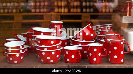 Sammlung roter und weißer Polka Dots Küchenartikel auf Holztisch, Schaufensterauslage. Retro-Küchenutensilien und Essaccessoires, Vintage-Ästhetik, nostalgisches Design, Emaildesign-Küchenutensilien-Konzept Stockfoto