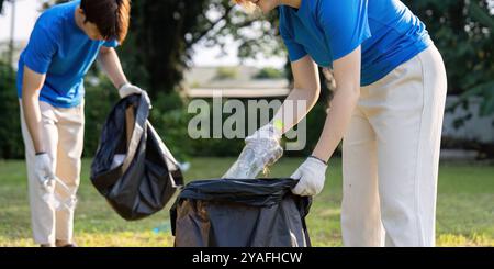 Begeisterte Freiwillige sammeln Müll in einem Park, um Umweltbewusstsein und Gemeinschaftsbeteiligung zu fördern Stockfoto