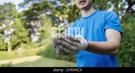 Junger Freiwilliger pflanzt Baum Sapling im Park, um Umweltschutz und Gemeindedienst zu fördern Stockfoto