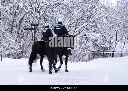 Die berittene Polizei patrouilliert in einem Snowy Park, Montreal Kanada Stockfoto