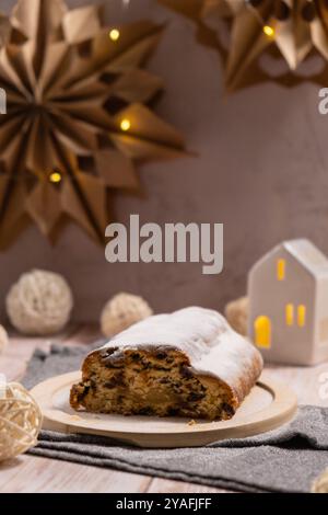 Traditioneller deutscher Weihnachtsstollenkuchen im Hintergrund mit handgemachter festlicher Dekoration. Winterferien. Zubereitung veganer Backrezepte Stockfoto