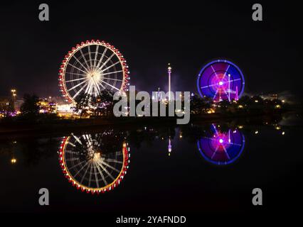 Nachtaufnahme, Übersicht, Reflexion im Neckar, Riesenrad, Europa Rad, Gladiator, Fahrgeschäfte, Bewegung, Bewegungseffekt, Cannstatter Wasen, Folk f Stockfoto