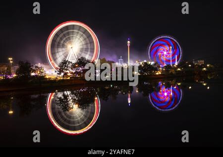 Nachtaufnahme, Übersicht, Reflexion im Neckar, Riesenrad, Europa Rad, Gladiator, Fahrgeschäfte, Bewegung, Bewegungseffekt, Cannstatter Wasen, Folk f Stockfoto