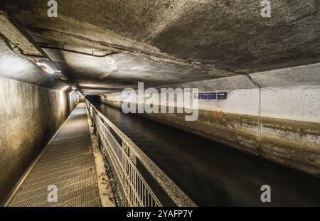 Anderlecht, Brüssel, Belgien, 07 16 2019 - der überdachte Fluss La Senne, mit einem Metallwanderweg am Kanalisationsmuseum und einem Mann, der wandert, Europa Stockfoto