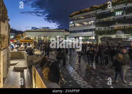 Altstadt von Athen, Attika, Griechenland, 12 28 2019 Einheimische und Touristen, die bei Nacht über den Monastiraki-Platz spazieren, Europa Stockfoto