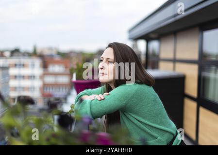 Porträt einer attraktiven, dreißigjährigen weißen Frau, die auf einer Terrasse posiert, Belgien, Europa Stockfoto