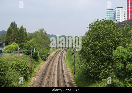 Ganshoren, Region Brüssel-Hauptstadt, Belgien, 18. Mai 2024, zweigleisige Bahnen der lokalen Eisenbahnen trtrhmen den Park, Europa Stockfoto