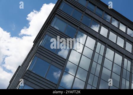 Boitsfort, Brüssel-Hauptstadt, Belgien, 05 20 2020 Blaue Wolken spiegeln sich in den Fenstern eines Bürohochhauses am Boulevard du Souverin, Stockfoto