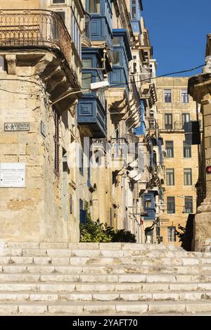 Valletta, Malta, 01 06 2022: Treppen und enge traditionelle Straße mit gelben Fassaden, Europa Stockfoto