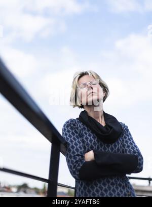 Porträt einer attraktiven 30-jährigen Frau, die mit geschlossenen Augen auf einer Terrasse posiert Stockfoto