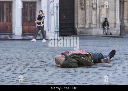 Brüssel Altstadt, Region Brüssel Hauptstadt, Belgien, 05 18 2020 älterer Mann liegt am Kopfsteinpflaster des Brüsseler Grand Place, Europa Stockfoto