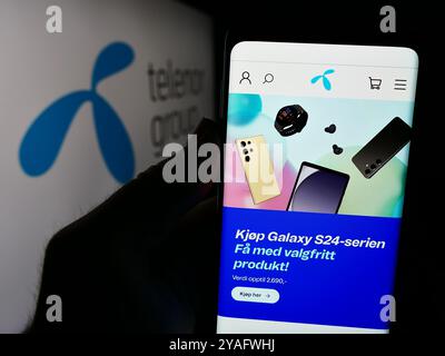 Deutschland. August 2024. In dieser Abbildung hält eine Person ein Smartphone mit der Webseite des norwegischen Telekommunikationsunternehmens Telenor ASA vor dem Logo. Quelle: SOPA Images Limited/Alamy Live News Stockfoto