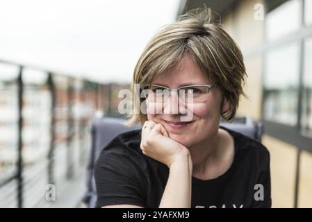 Porträt einer attraktiven 30-jährigen Frau, die zu Hause auf einer Terrasse posiert Stockfoto