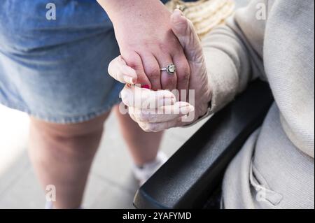 83-jährige weiße ältere Frau, die die Hand ihrer 39-jährigen Tochter mit Down-Syndrom hält, Tienen, Belgien, Europa Stockfoto