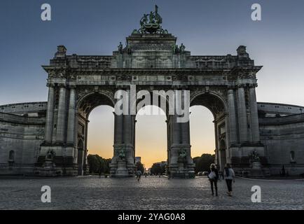 Brüssel, Belgien, 06 26 2018: Touristen spazieren unter den Arkaden des Cinquentenaire-Denkmals bei Sonnenuntergang, Europa Stockfoto