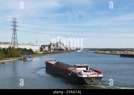 Genk, Limburg, Belgien, 04 12 2022, industrielle Tätigkeit und ein Windmühle-betriebenes elektronisches Werk am Ufer des Albert-Kanals, Europa Stockfoto