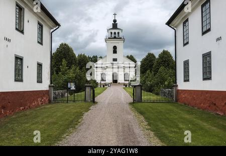 Forsmark, Osthammar, Schweden, 07 31 2019 Weg, traditionelle Häuser und Gärten zur evangelischen Kirche, Europa Stockfoto