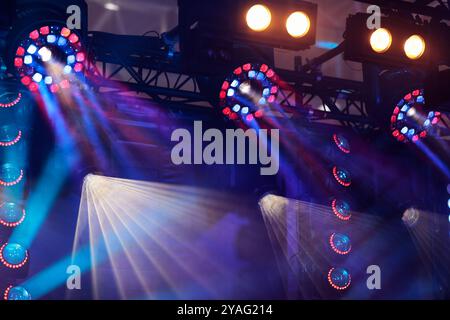 Konzertszene mit farbenfroher Bühnenbeleuchtung. Verschiedene LED-Beleuchtungskörper, die an einem Fachwerk hängen. Selektiver Fokus. Stockfoto