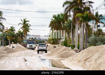 Stock Fotomodellaster, die nach Hurrikan Milton Sturm Flut und Flut Tonnen Sand von Bonita Beach Florida entfernen Stockfoto