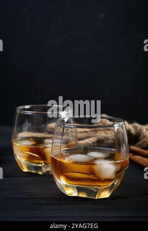 Glas Whiskey mit Eis auf dunklem Hintergrund Stockfoto