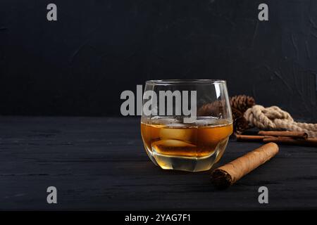 Glas Whiskey mit Eis auf dunklem Hintergrund Stockfoto
