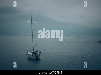 Einsames Segelschiff mit Berg Stockfoto