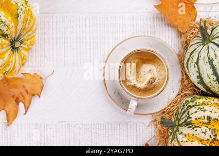 Speisen im Herbst-Stil mit Kaffee, Kürbissen und Herbstblättern auf einem Tisch für eine gemütliche, saisonale Atmosphäre. Enthält Kopierbereich für Ihren Stockfoto