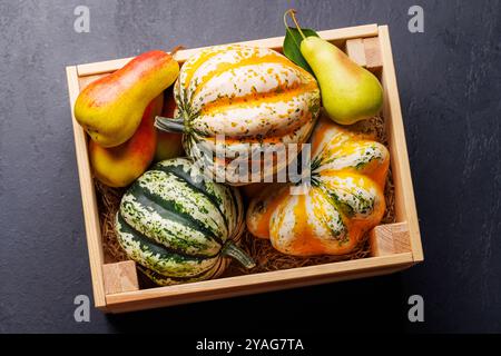 Herbstmotiv mit Kürbissen und Birnen in einer Box, die eine gemütliche, saisonale Atmosphäre schafft Stockfoto