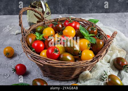 Mehrfarbige Tomaten im Korb. Verschiedene Arten frischer Tomaten Stockfoto
