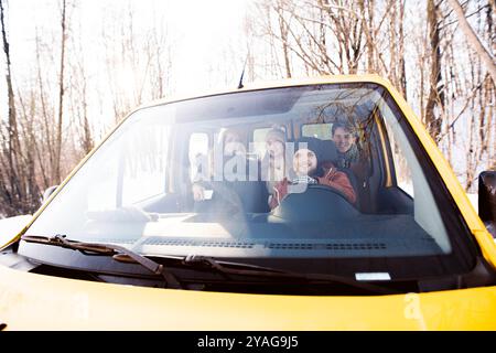 Freunde, die in den Winterferien mit dem Auto unterwegs sind und Weihnachten in der Kabine verbringen. Fahrt durch verschneite Landschaft. Stockfoto