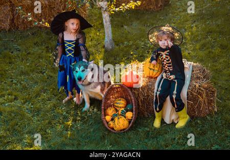 Niedliche Kinder in Halloween-Kostümen, die Spaß an Halloween haben. Glückliche Kinder auf Halloween-Party. Halloween-Kinderparty im Garten mit Stockfoto