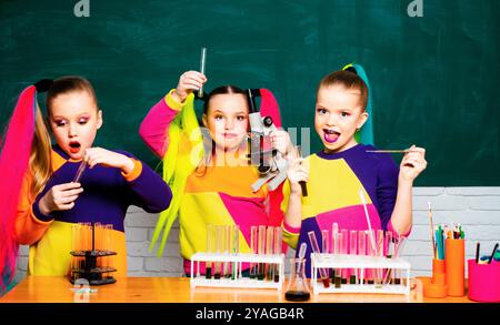 Spaß und einfache Wissenschaft. Junge Wissenschaftler machen ein chemisches Experiment im Labor an der schuleauf dem Hintergrund der Tafel. MINT- und Wissenschaftsprojekte Stockfoto