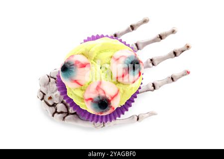 Skeletthand mit köstlichem Halloween-Cupcake auf weißem Hintergrund Stockfoto