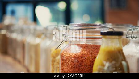 Verschiedene Teigwaren und Getreidearten, die in wiederverwendbaren Gläsern gelagert und als Massenware verkauft werden, Waren im Nullmüll-Naturgeschäft. Umweltfreundlicher Supermarkt. Handgeführte Aufnahme. Nahaufnahme. Stockfoto