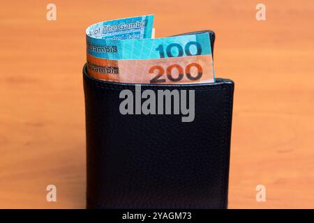 Gambische Geld - Dalasi in der schwarzen Brieftasche Stockfoto