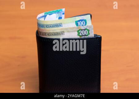Gambische Geld - Dalasi in der schwarzen Brieftasche Stockfoto