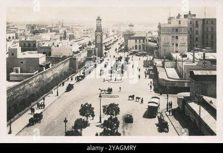 Alte Fotopostkarte aus den 1930er Jahren des Place de France (heute Platz der Vereinten Nationen) in Casablanca, Marokko. Im Hintergrund befindet sich die Tour de l'Horloge (Uhrenturm), die noch heute dort ist. Stockfoto