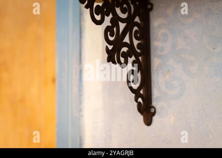 Innenraum in Pastellfarben mit Regaldetails, Hintergrund. Vintage schmiedeeiserne Regalhalterung mit Schatten. Hintergrund innen. Stockfoto