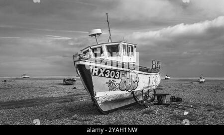 Ein Schwarzweiß-Bild eines alten verlassenen Bootes in Dungeness, der Landzunge bei Denge, an der Küste. Stockfoto