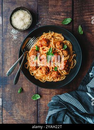 Blick von oben auf den Teller mit Spaghetti und Fleischbällchen auf dem Holztisch. Stockfoto