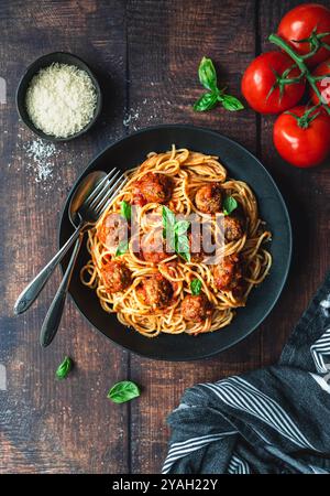 Blick von oben auf den Teller mit Spaghetti und Fleischbällchen auf dem Holztisch. Stockfoto