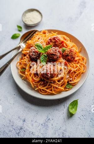 Nahaufnahme eines Tellers mit Spaghetti und Fleischbällchen auf hellem Hintergrund. Stockfoto